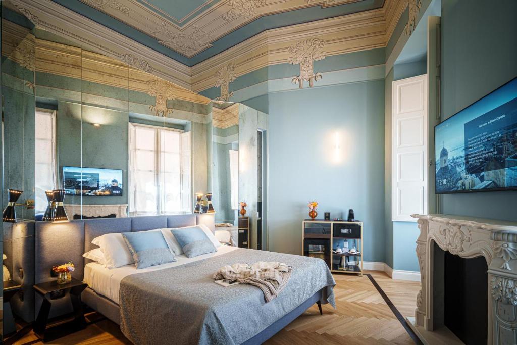 Un dormitorio con una cama y un televisor. en Albergo Diffuso Birkin Castello, en Cagliari