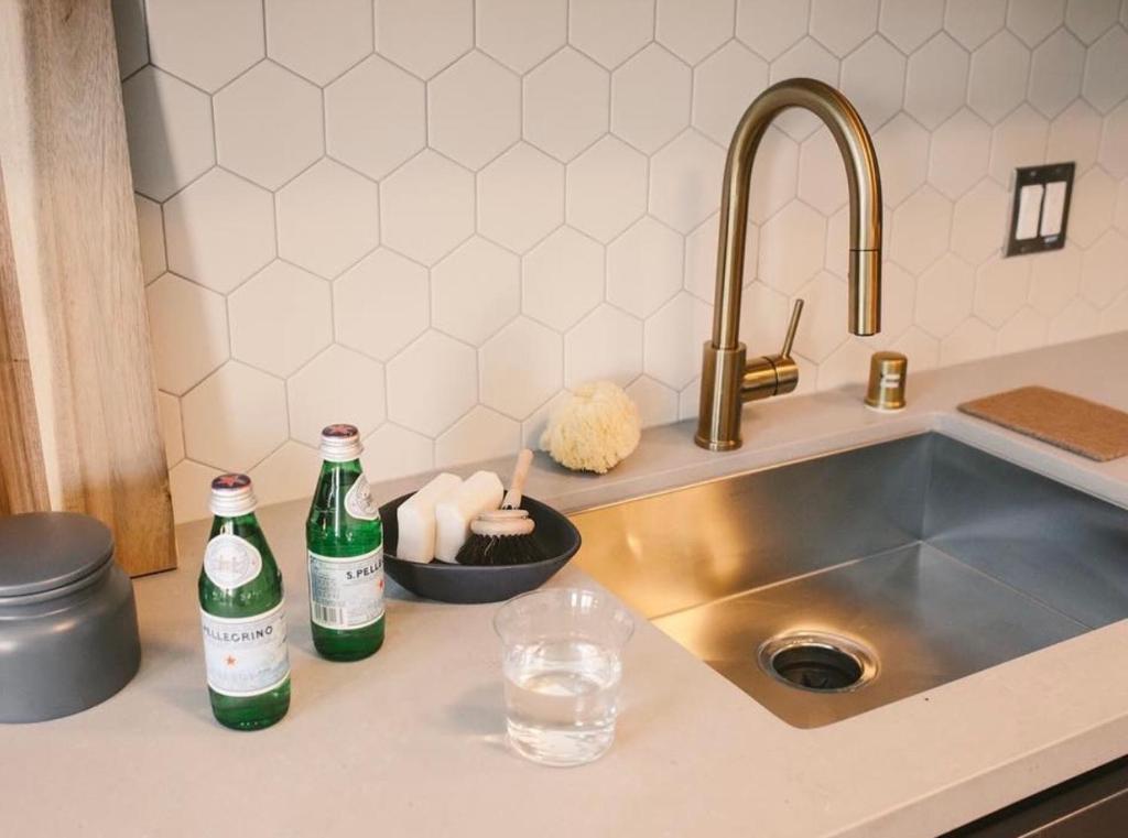- un comptoir de cuisine avec 2 bouteilles sur un évier dans l'établissement Hollywood Luxury Pent house, à Los Angeles