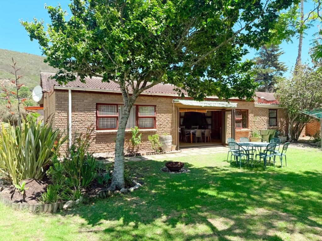 克尼斯纳Brenton Park Cottage 15的院子内有桌子和树的房子