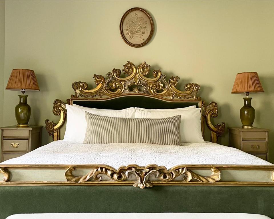 Un dormitorio con una cama adornada con dos lámparas. en The Green, en Wingfield