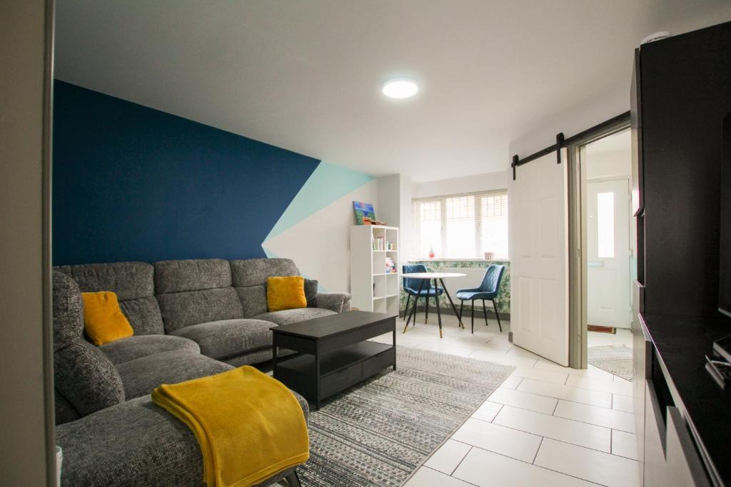 a living room with a couch and a blue wall at Modern 3-Bedroom Home in Quiet Cul-de-Sac w Parking by Rework Accommodation in Saltney