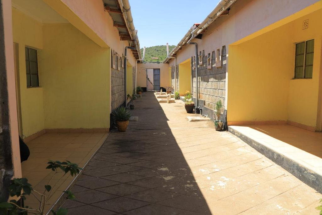 pusty korytarz budynku z żółtymi ścianami w obiekcie Enaitoti Hotel w mieście Aitong