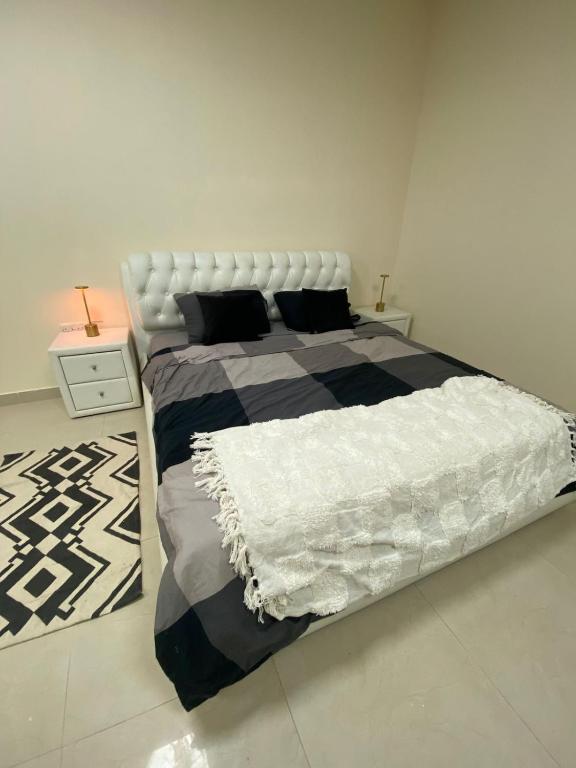 Un dormitorio con una cama grande y una alfombra. en Studio, en Abu Dabi