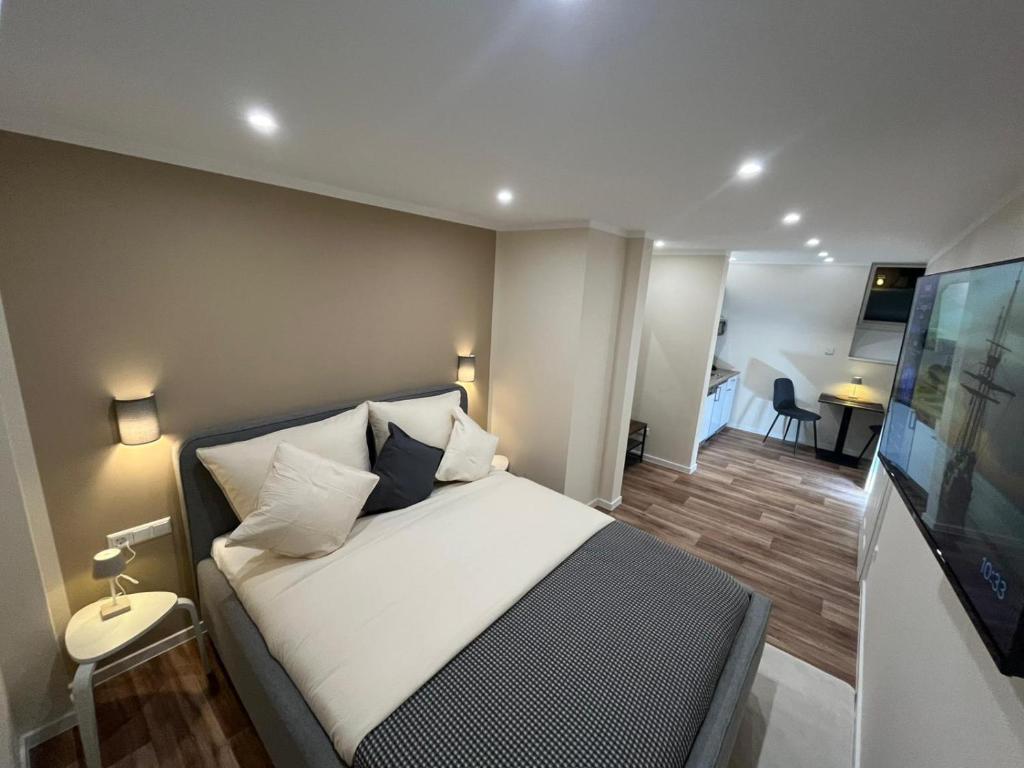 Lumio Apartment 1 في كارلسروه: غرفة نوم مع سرير وتلفزيون بشاشة مسطحة