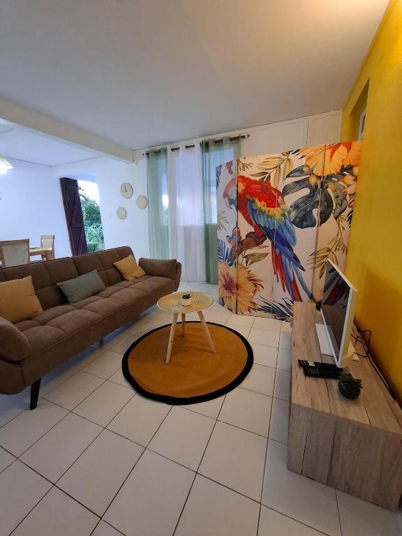 a living room with a couch and a table at Logement chaleureux confortable - 2 chambres - Aveline in Petit-Canal