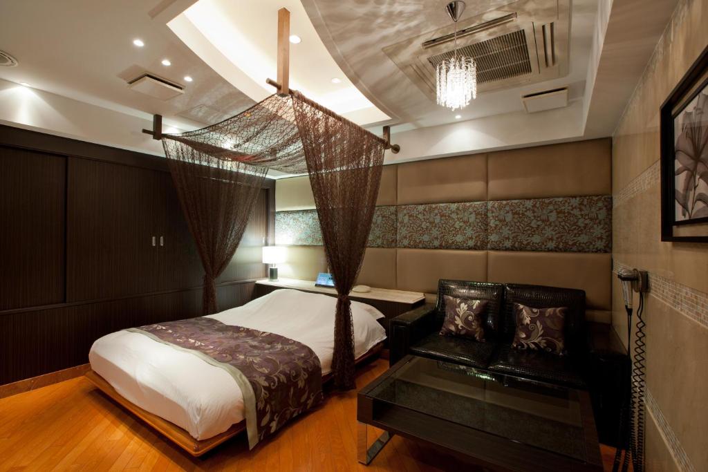 a bedroom with a bed and a table and a hammock at HOTEL AN Shinjuku Kabukicho (Adult Only) in Tokyo
