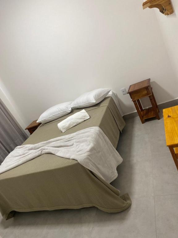 un letto con due cuscini e un tavolo in una stanza di Hotel Terras a Teixeira de Freitas