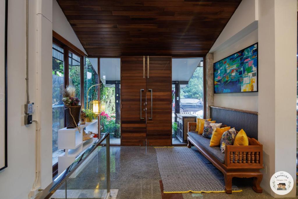 un soggiorno con divano e porta a vetri di Lannatika Villa a Chiang Mai