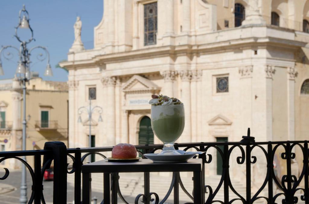 a vase sitting on a table with an apple on it at Garibaldi Rooms, Boutique Stay in Val di Noto with Piazza & Church Views in Rosolini