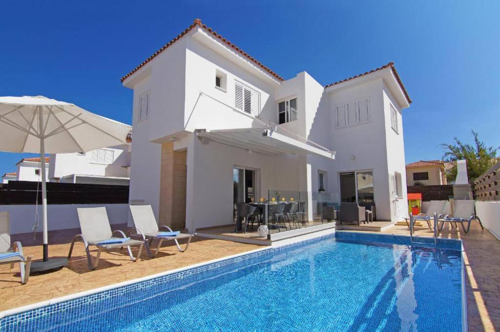 eine Villa mit einem Swimmingpool vor einem Haus in der Unterkunft Elite Luxury Villa in Paralimni