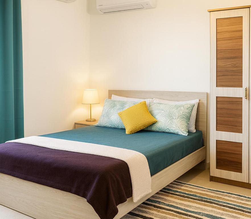 a bedroom with a bed with colorful pillows at Grand Baie Holiday Apartment in Grand Baie