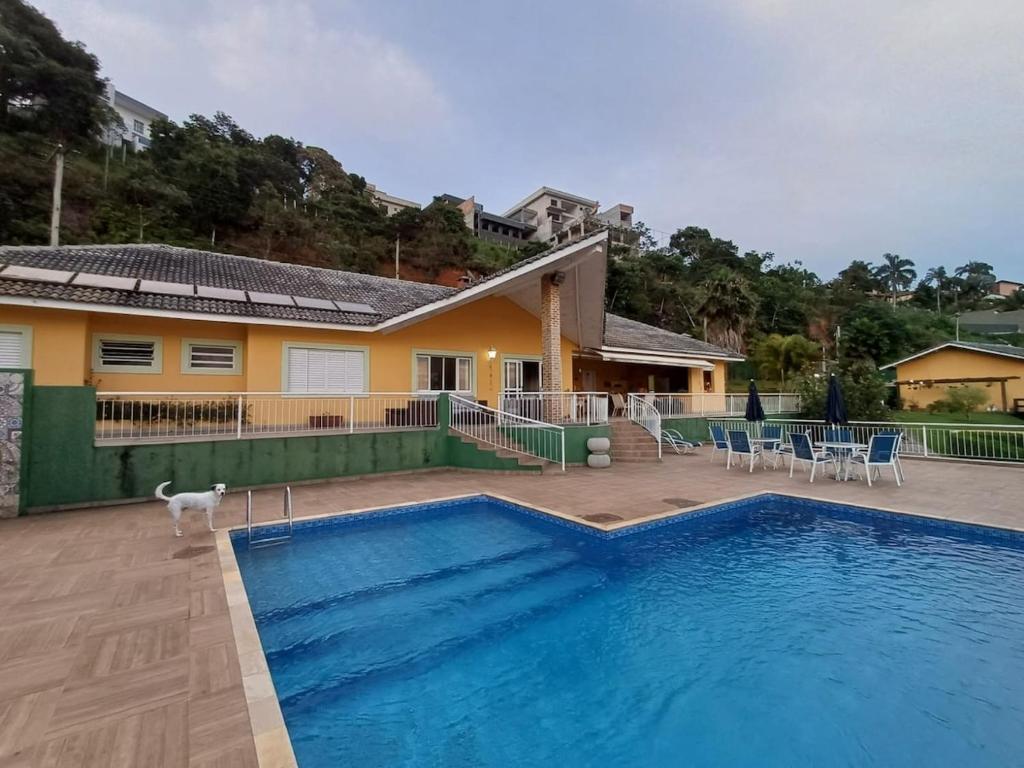una piscina davanti a una casa di Represa de Igaratá Yellow House a Jacareí