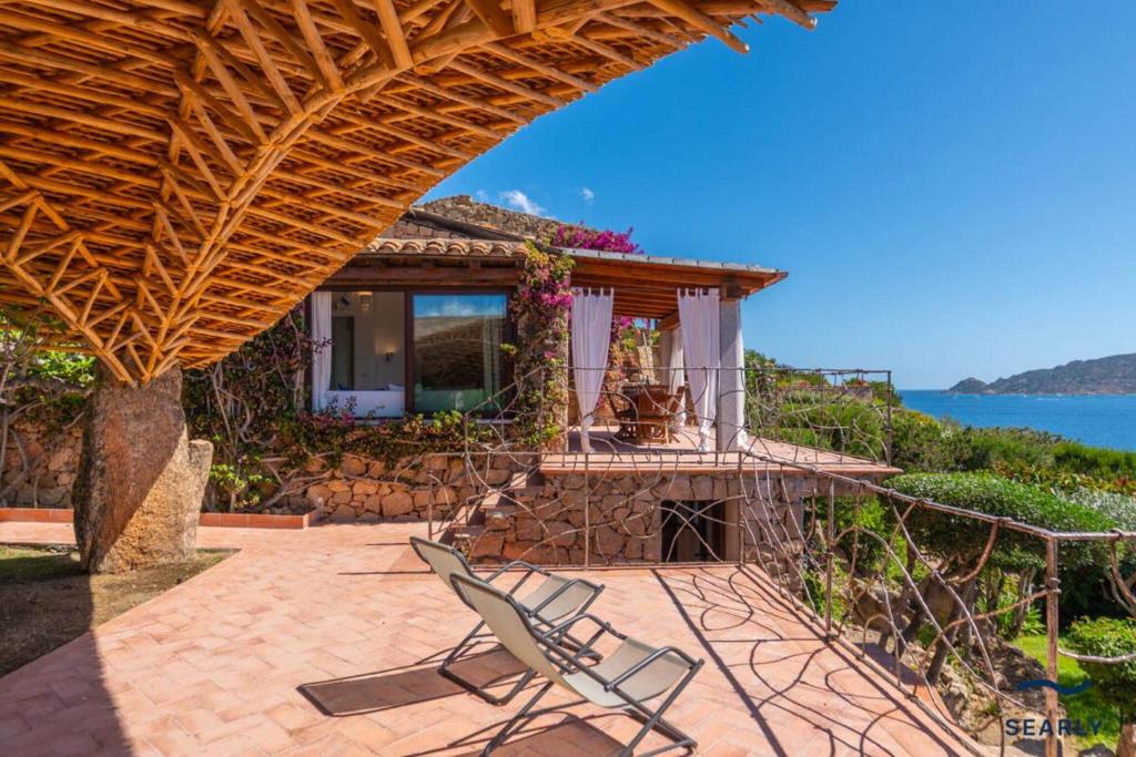 Punta MolaraVilla Piperita - By Searly的一个带两把椅子的庭院和一座水屋