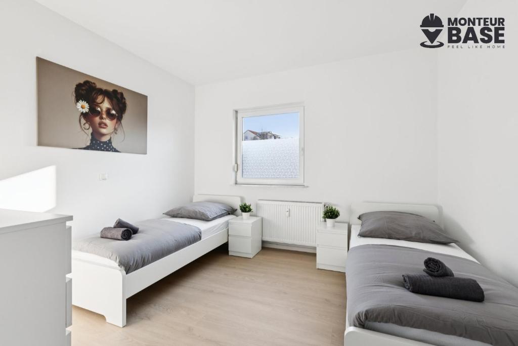 Dos camas en una habitación con paredes blancas. en MONTEUR - Unterkunft für bis zu 5 Personen in 63452 Hanau - HU14, en Hanau am Main