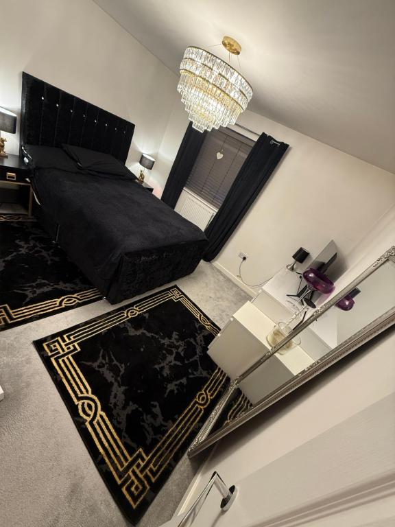 a bedroom with a black bed and a glass table at The Secret Stay In Walsall in Walsall