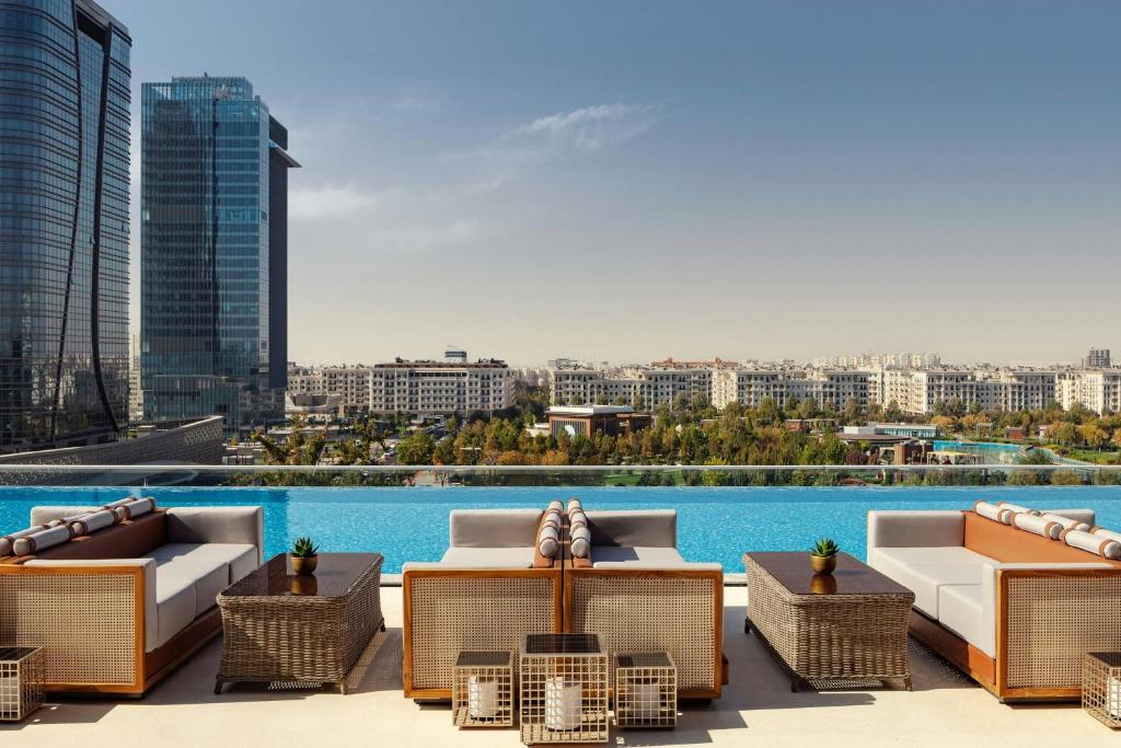 a rooftop patio with chairs and tables on a building at JW Marriott Hotel Tashkent in Tashkent