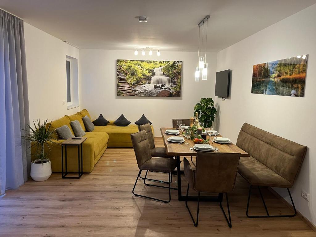a living room with a table and a yellow couch at Ferienappartement Sieger in Großkirchheim