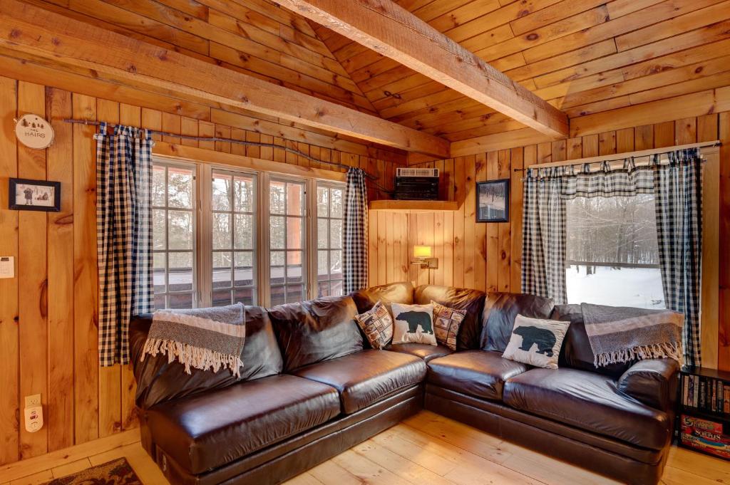 a living room with a leather couch in a cabin at Secluded 2br Cabin W Hot Tub, Pond, Trails, Wifi in Granby