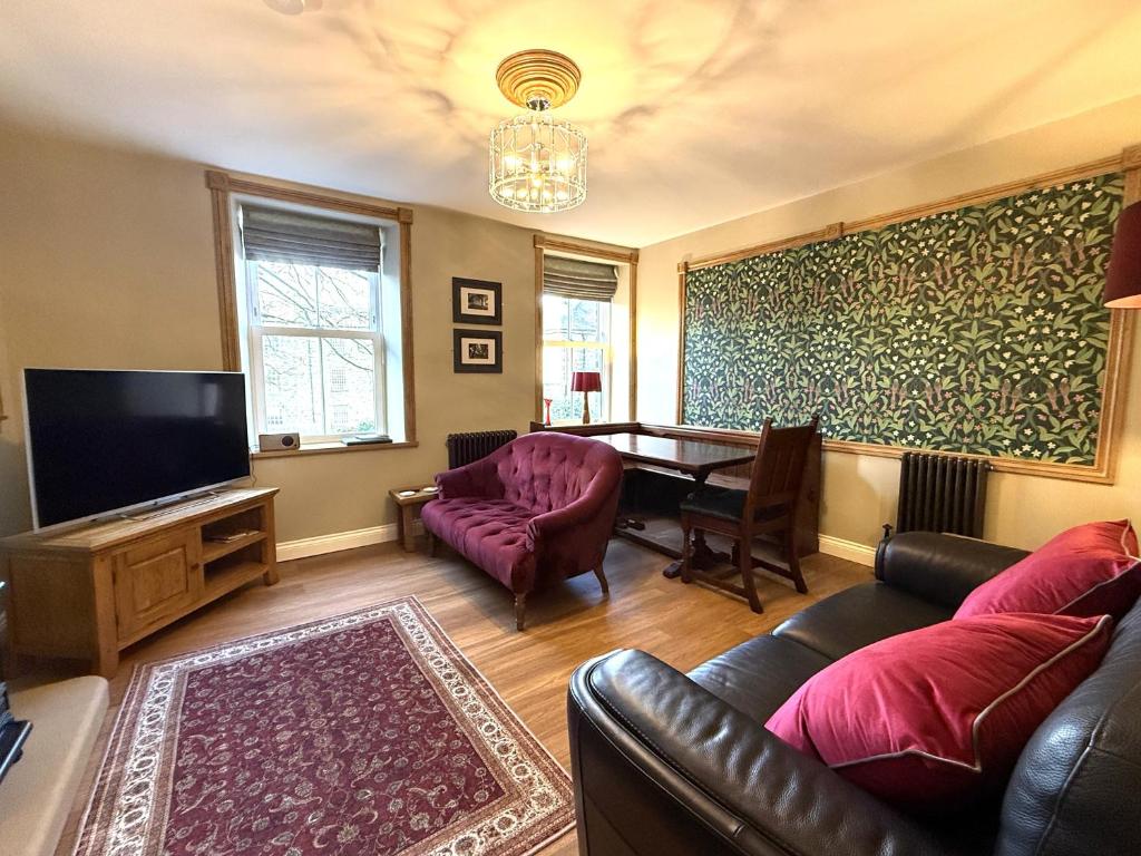 ein Wohnzimmer mit Sofa und Tisch in der Unterkunft Spinners View - Elegant Victorian Duplex Central Skipton & Parking in Skipton