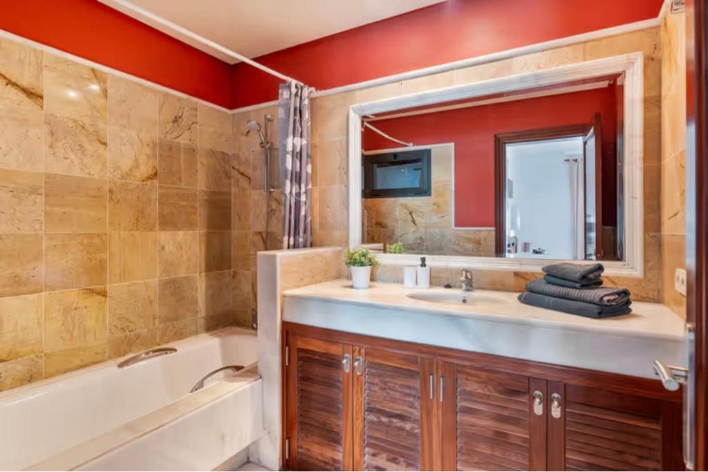ein Badezimmer mit Badewanne, Waschbecken und Spiegel in der Unterkunft Villa Tania - Villa independiente con piscina privada in Playa Blanca