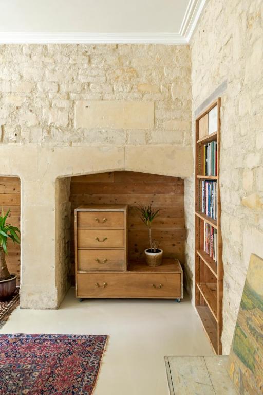 a room with a wooden dresser and a brick wall at The Georgian Studio in Bath