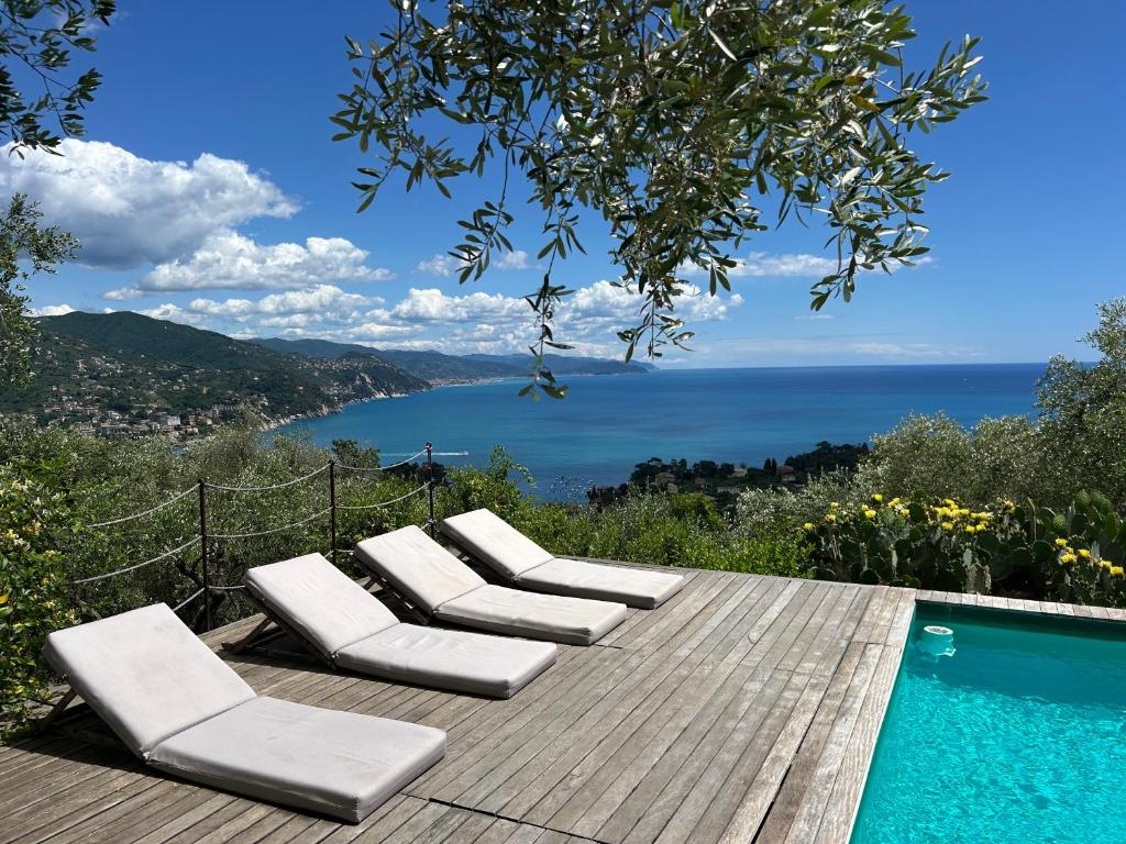 a deck with lounge chairs next to a swimming pool at CHARMING APARTMENT VILLA WITH POOL 010-46-cav-0009 in Rapallo