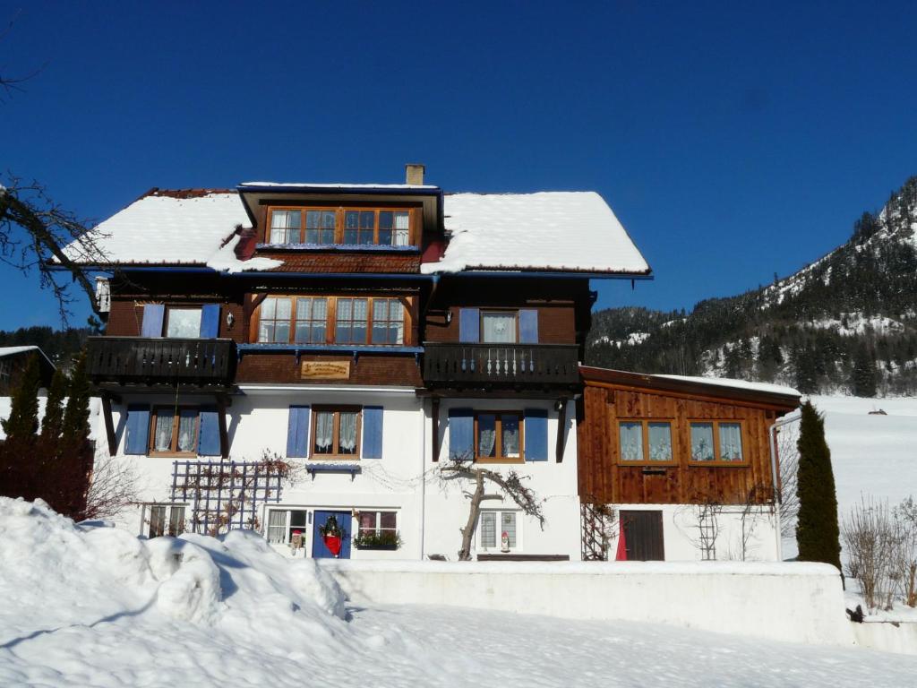 a building covered in snow with snow at Bad Hindelang in Bad Hindelang