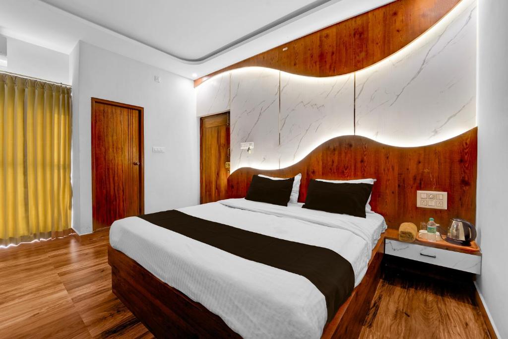 Vānivilāsa PuramHotel O Udaya Residency的卧室里有一张带木质床头板的大床