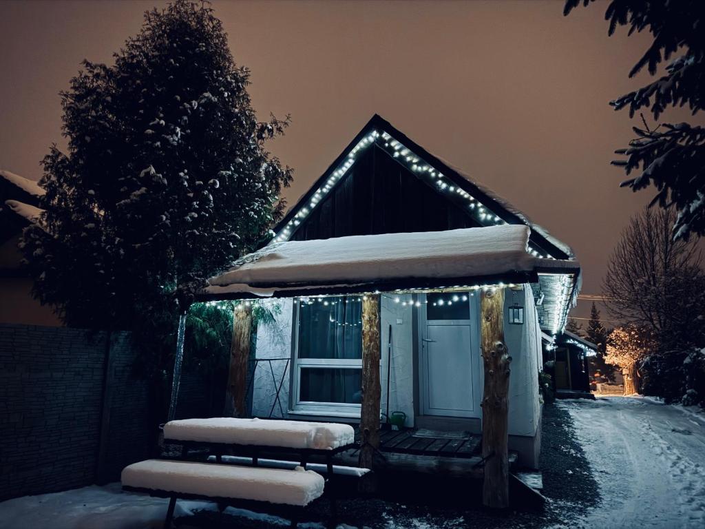 una casa coperta di neve con le luci di Chalupa M&P 2 a Bešeňová