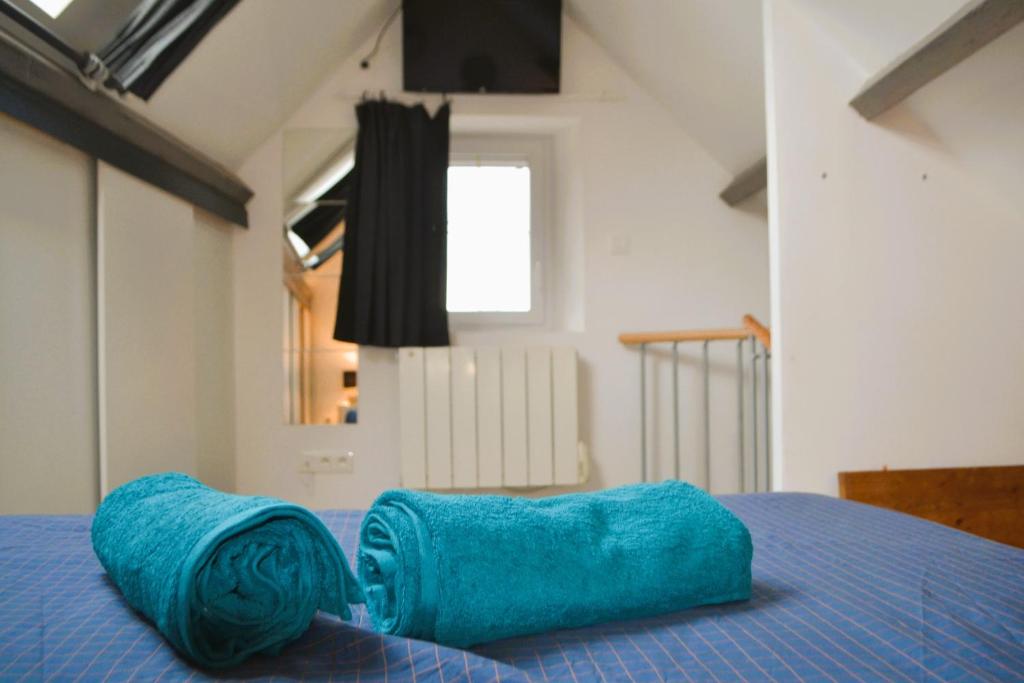 La Blanche des Marais, maison de ville في Picauville: وسادة زرقاء موضوعة فوق السرير