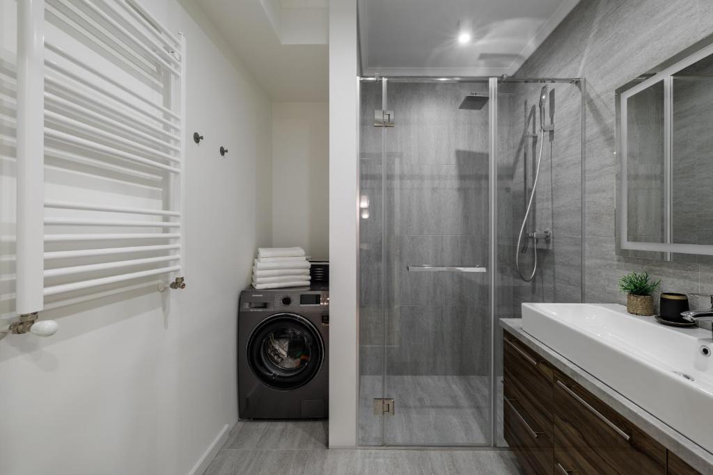 une salle de bain avec une machine à laver dans une douche dans l'établissement Soul Rentals 2BR Cozy Apt, New Block & Calm Gem, à Chişinău