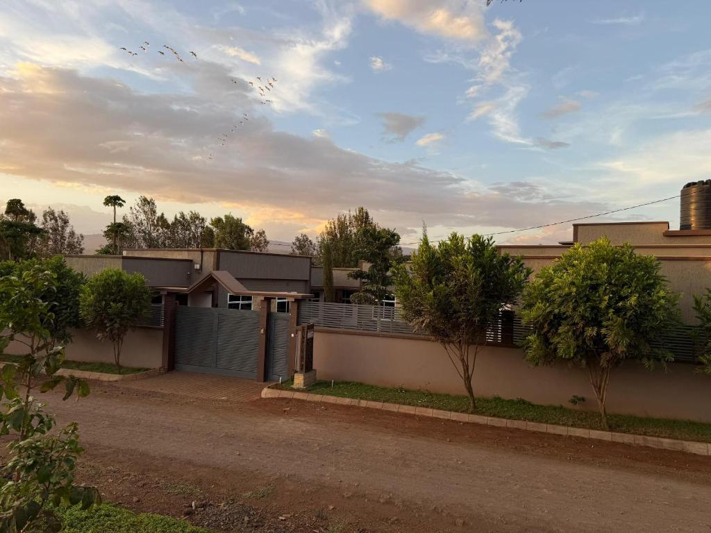 una casa con una recinzione di fronte a una strada di Cj VILLA a Karatu