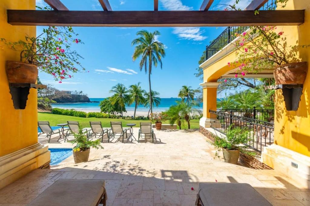 uma vista para a praia a partir de uma casa em Spectacular Mediterranean-Style Mansion with Beachfront Views in Playa Flamingo em Playa Flamingo