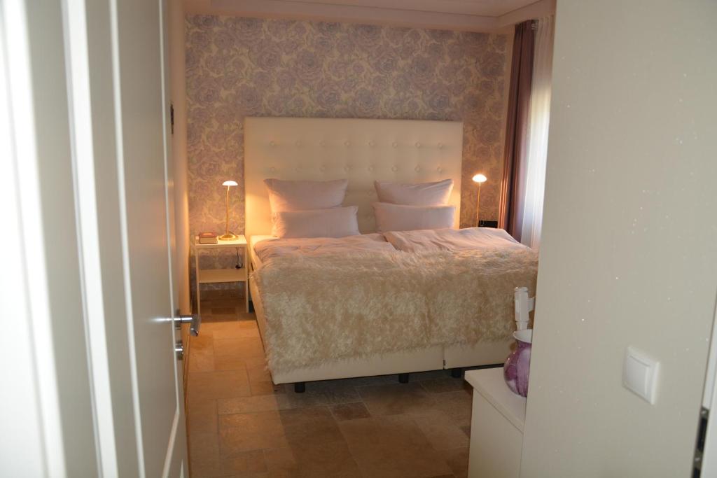 um quarto com uma cama com uma colcha branca e uma mesa de cabeceira em Wir Beide em Elten