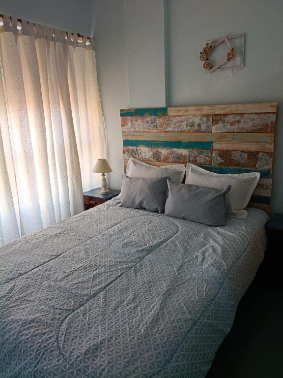 a bedroom with a large bed with a wooden headboard at Magnolia Vintage in San Bernardo