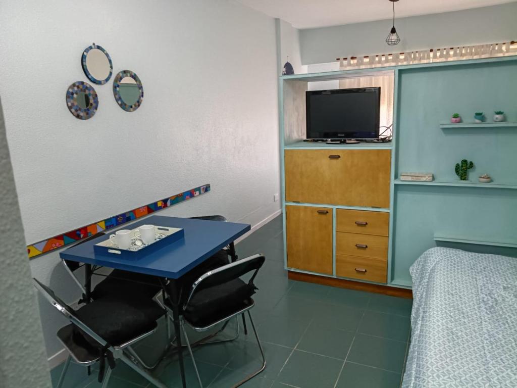 een kamer met een tafel, een bed en een televisie bij Magnolia Vintage in San Bernardo