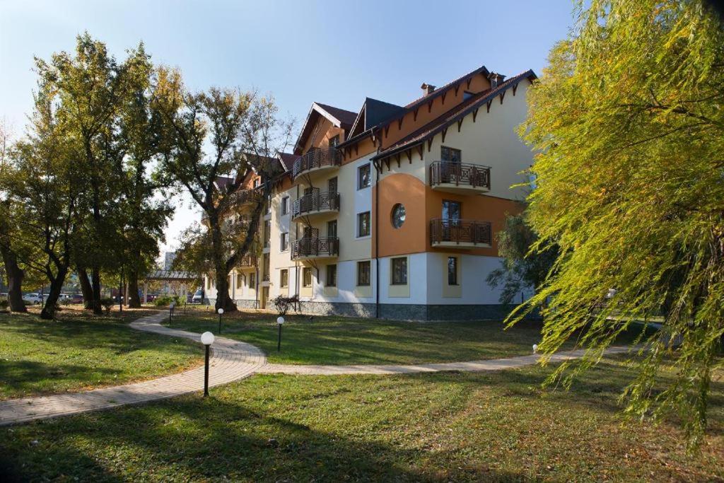 a building in a park with trees and grass at Drazdiak House Antolska Lake View in Bratislava