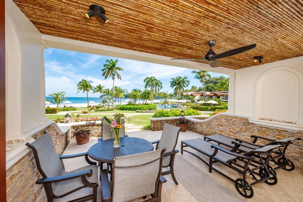 Un patio con mesa y sillas y el mar. en Upscale Two-Bedroom Condo in Playa Flamingo with Beautiful Oceanfront Views, en Playa Flamingo