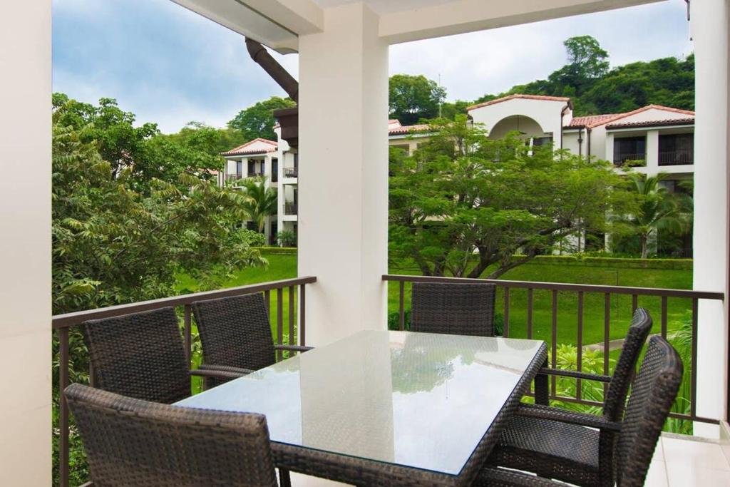 a patio with a table and chairs on a balcony at Coastal-Inspired Condo with a Pool-View Balcony & Beach Club Access in Coco