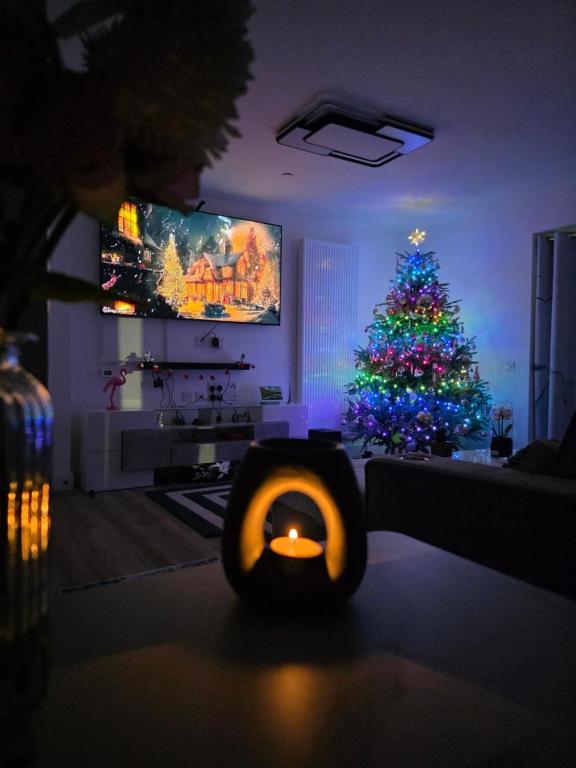 The HydeCozy bedroom 2 in a Charming London Flat的客厅里摆着一棵圣诞树和一支点燃的蜡烛