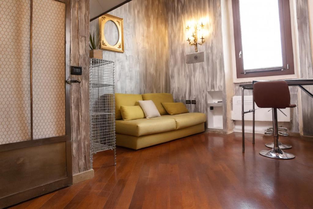a living room with a yellow couch and a table at Urban Loft 56 Moscova- Metro 2 min - TheModelsApartment in Milan