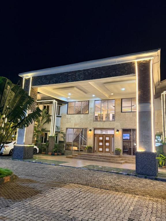 Ein großes Gebäude bei Nacht, davor ein Auto geparkt. in der Unterkunft Brava Hotel in Ibadan