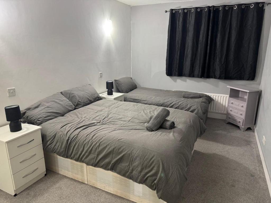 a bedroom with two twin beds and a window at East Croydon Comfort Apartments in Croydon