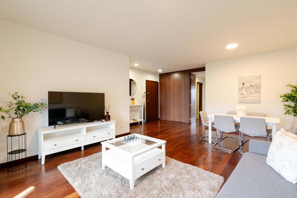 a living room with a large television and a table at Modern & Spacious Flat with Garage by HostWise in Vila Nova de Gaia
