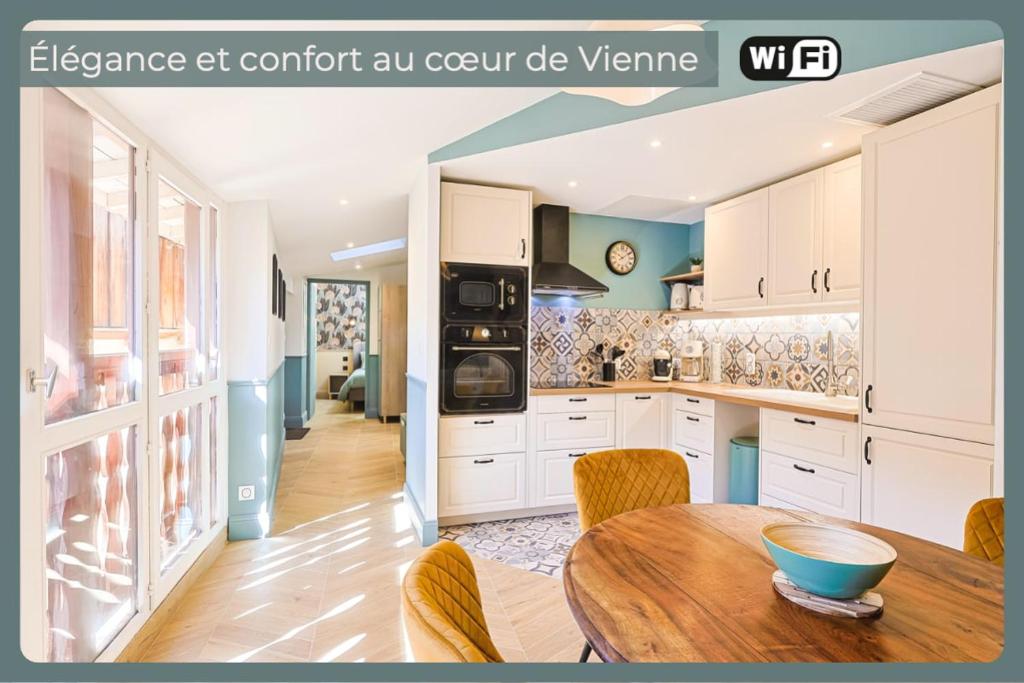 L'Allobroge - Charme & confort au cœur de Vienne في فيين: مطبخ بخزائن بيضاء وطاولة خشبية