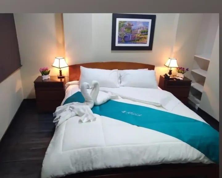 een slaapkamer met een bed met daarop een vogelbeeld bij Hotel RUAH in Tumbes