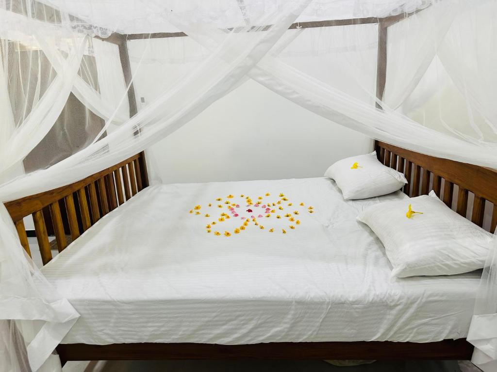 a bed with white sheets and stars on it at Villa Cinnaro in Ahangama