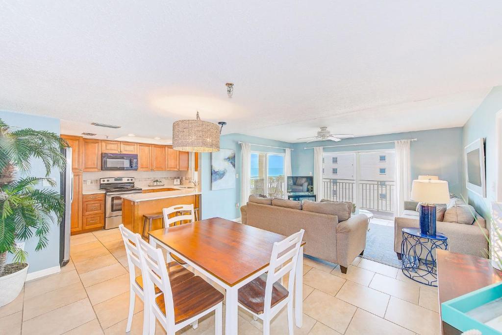 Una cocina y una sala de estar con mesa y sillas. en Beachfront Condo Sleeps 10 Heated Pool - 307, en St Pete Beach