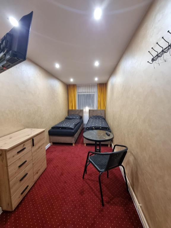 a room with a bed and a table and a chair at stary PGR rooms & hostel in Grabik