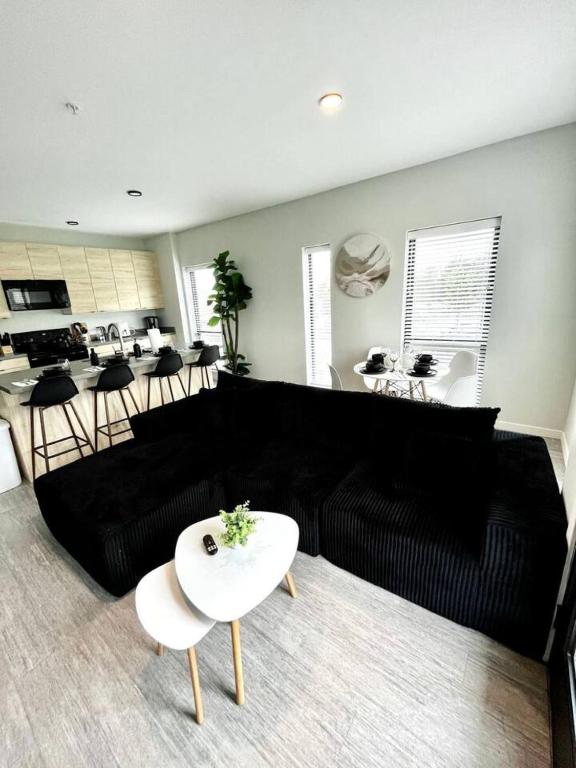 a living room with a black couch and a table at Monochrome Den in Des Moines